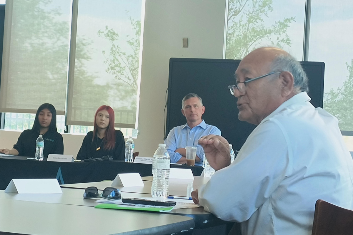 Anthony Yepa talks during a roundtable discussion about Medicaid cuts while Sen. Martin Heinrich listens.