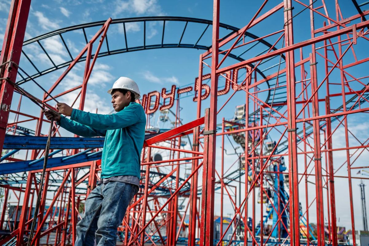 Jonathan Sandoval continues to work building the Indy-500 roller coaster ride at the State Fairgrounds, a week before the start of the 2025 New Mexico State Fair. Credit: Photo by Roberto E. Rosales/ New Mexico News.